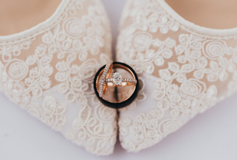 Wedding photo session with wedding rings  stacked on bride's shoes