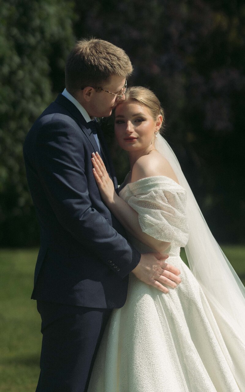 A beautiful moment of a couple holding each other, with the woman gazing at the camera, capturing their connection and elegance