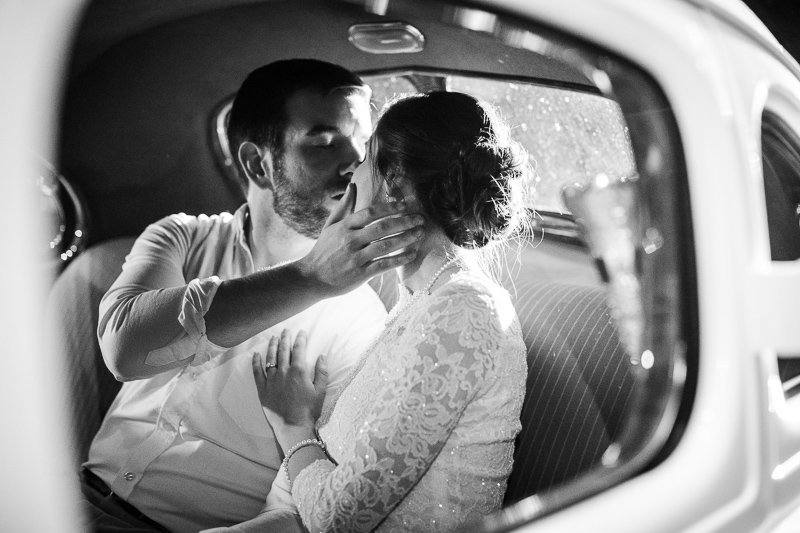 Classic black and white image of bride and groom in get-away car.