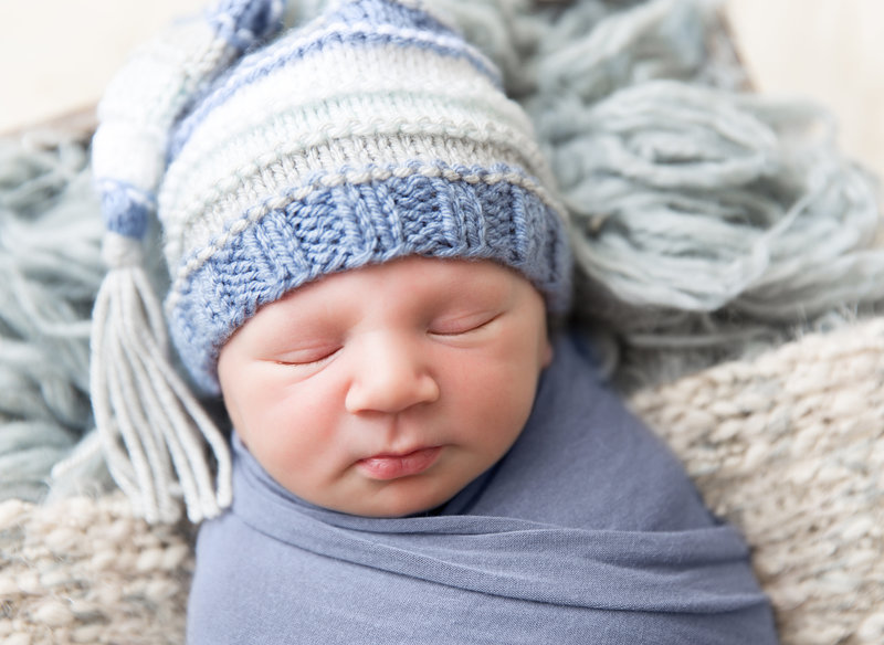 baby boy with blue and white tassel hat