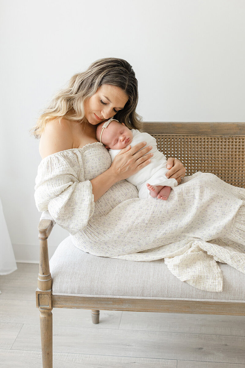 Mom in white floral  dress holding baby boy at newborn session philadelphia