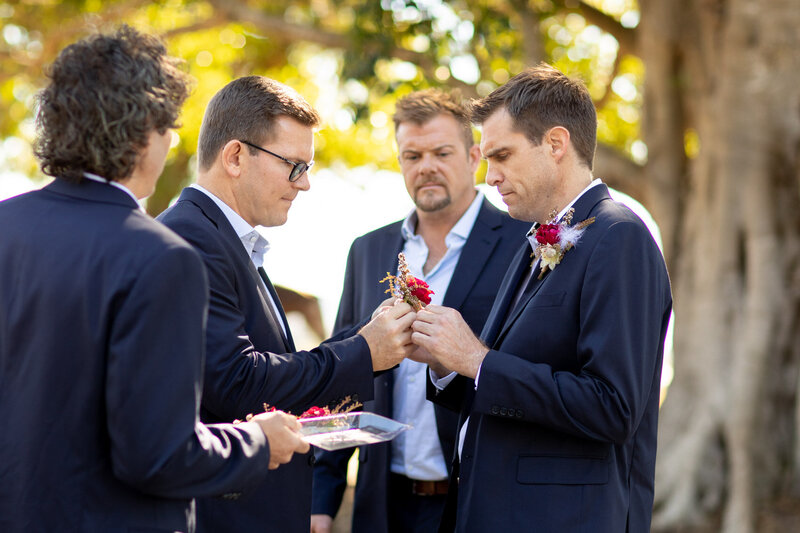 Groom and groomsmen distributing each of their boutonniere