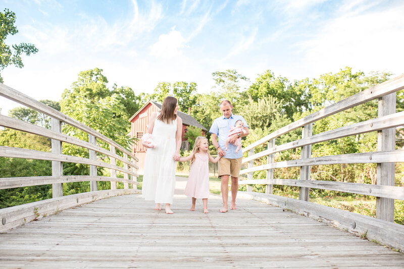 Ann Arbor Newborn Photographer captures family on bridge off of Hines Drive at Nankin Mills Recreation Area