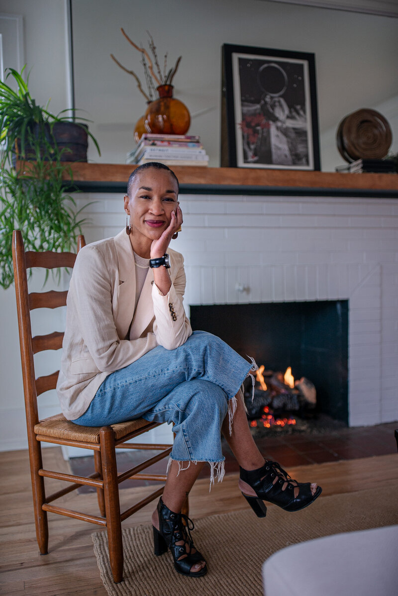 Michaela Ayers sitting on a chair infront of the fire place and smiling at the camera