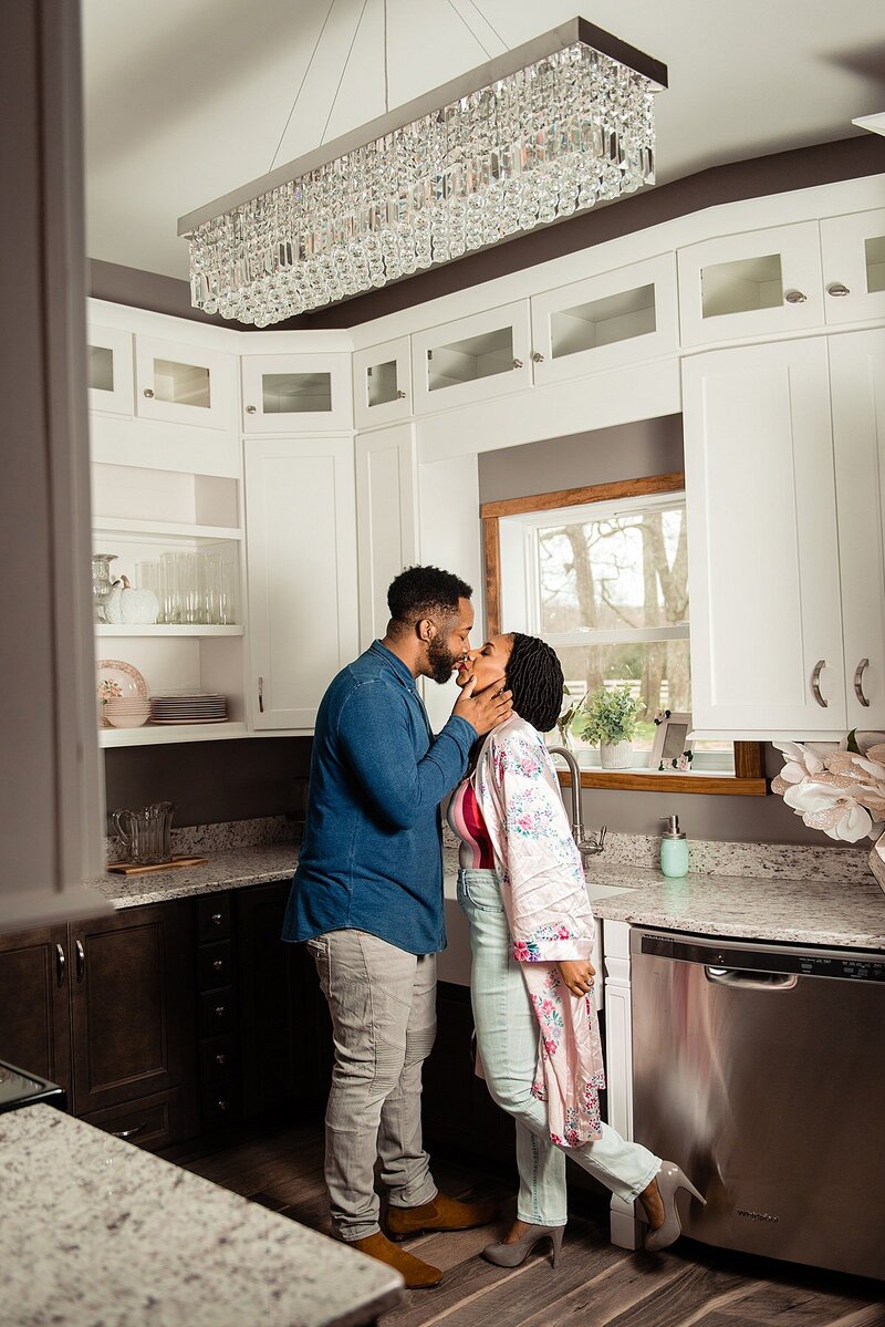 Couple sharing a sweet kiss while standing in their kitchen together