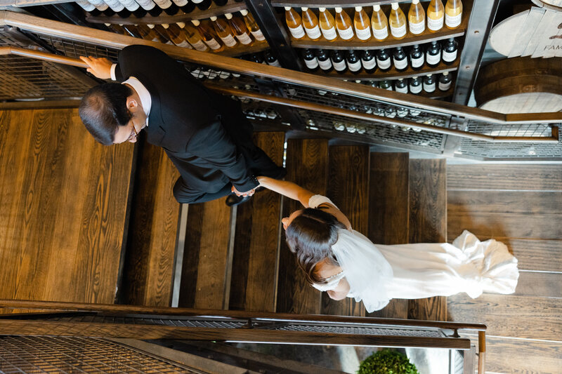 photo of bride and groom walking up staircase