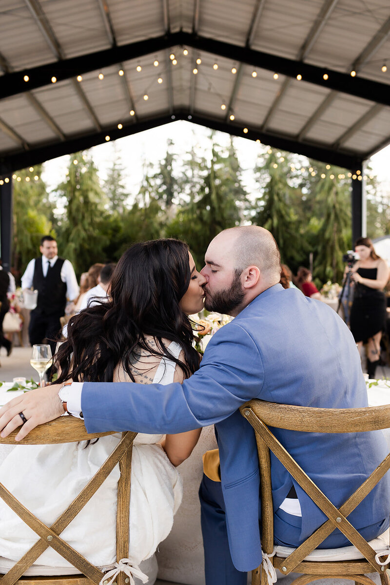 couple kissing during wedding reception