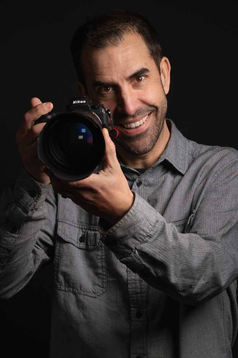 Wedding Photographer Eric Smyklo holding a Nikon camera.