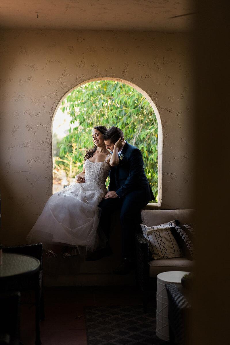 Bride and groom in an arched window, showing their silhouette