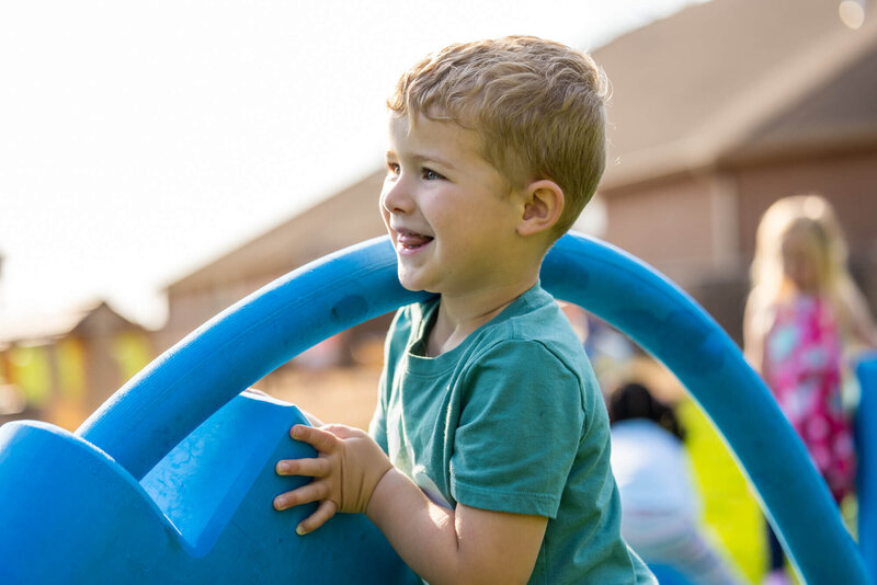 young boy playing outside with foam playground blocks