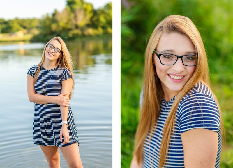 high school senior girl wearing striped dress posed with lake in backdrop
