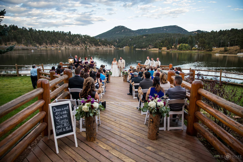 Wide view of the entire Evergreen Lake House back deck set up for a wedding ceremony at sunset