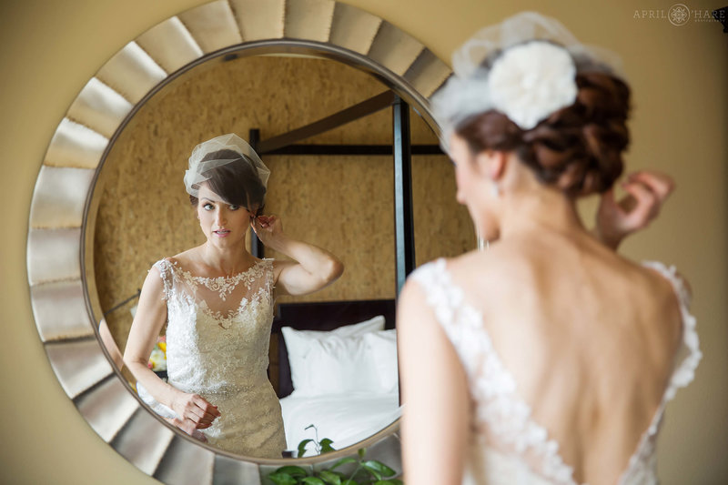 Bride touches up her hair using modern mirror in her St Julien Hotel Suite