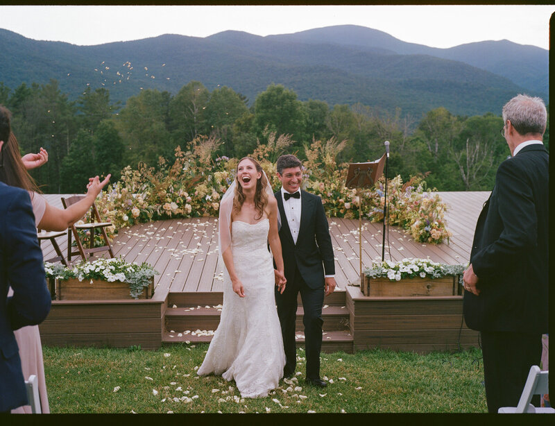 Film photo of bride and groom exiting their mountain wedding ceremony in vermont 
