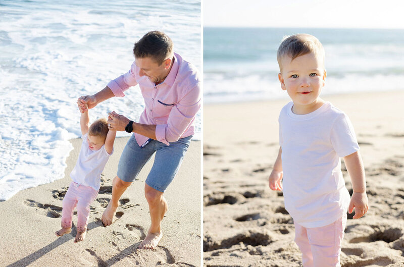 A dad wearing a pink shirt swings his young son around on the beach while playing together during their beach portrait session