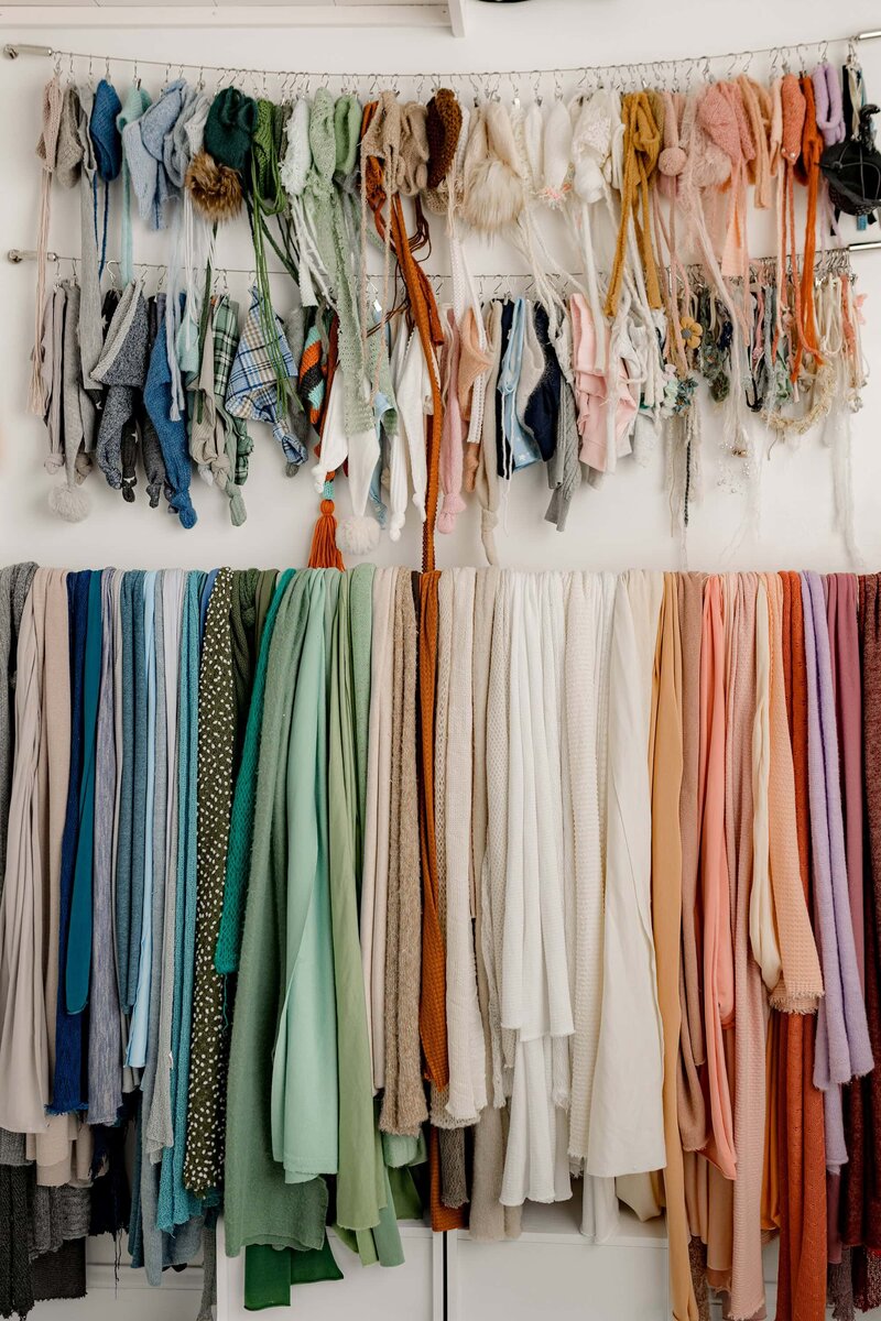 newborn wraps in a variety of colors with headbands and bows hanging above