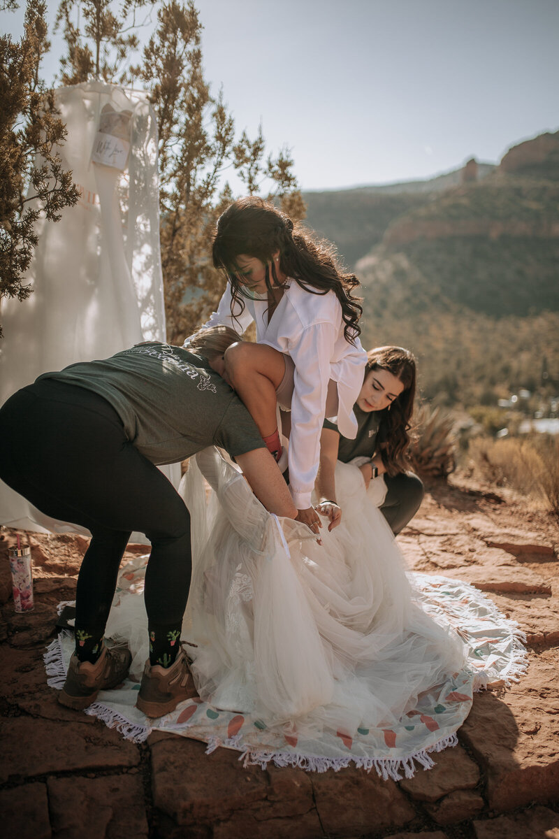 getting into her wedding dress outside on a hike
