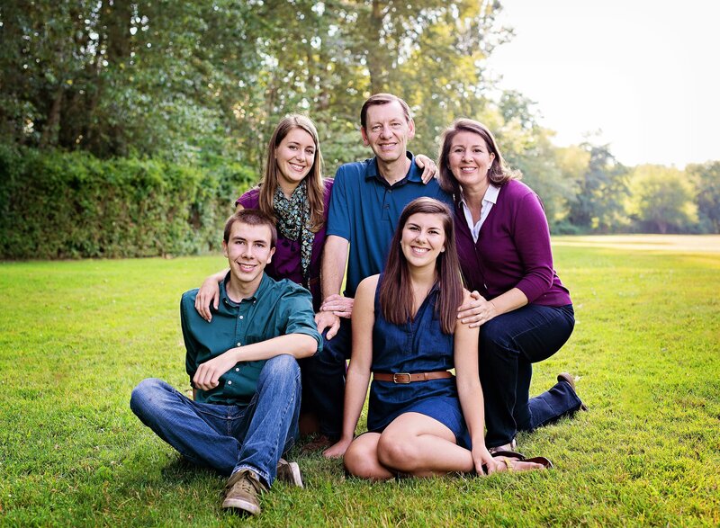 Family gathers for portrait on grassy field