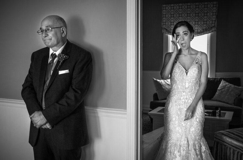 A father standing around the corner of a doorway as his daughter walks out in her wedding dress.