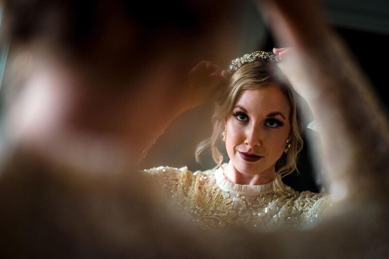 A bride at the Line Hotel in Washington DC looks back on her reflection with makeup and headpiece