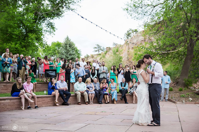 Wedding reception guests look at couple dancing their first dance at Riverbend in Lyons Colorado