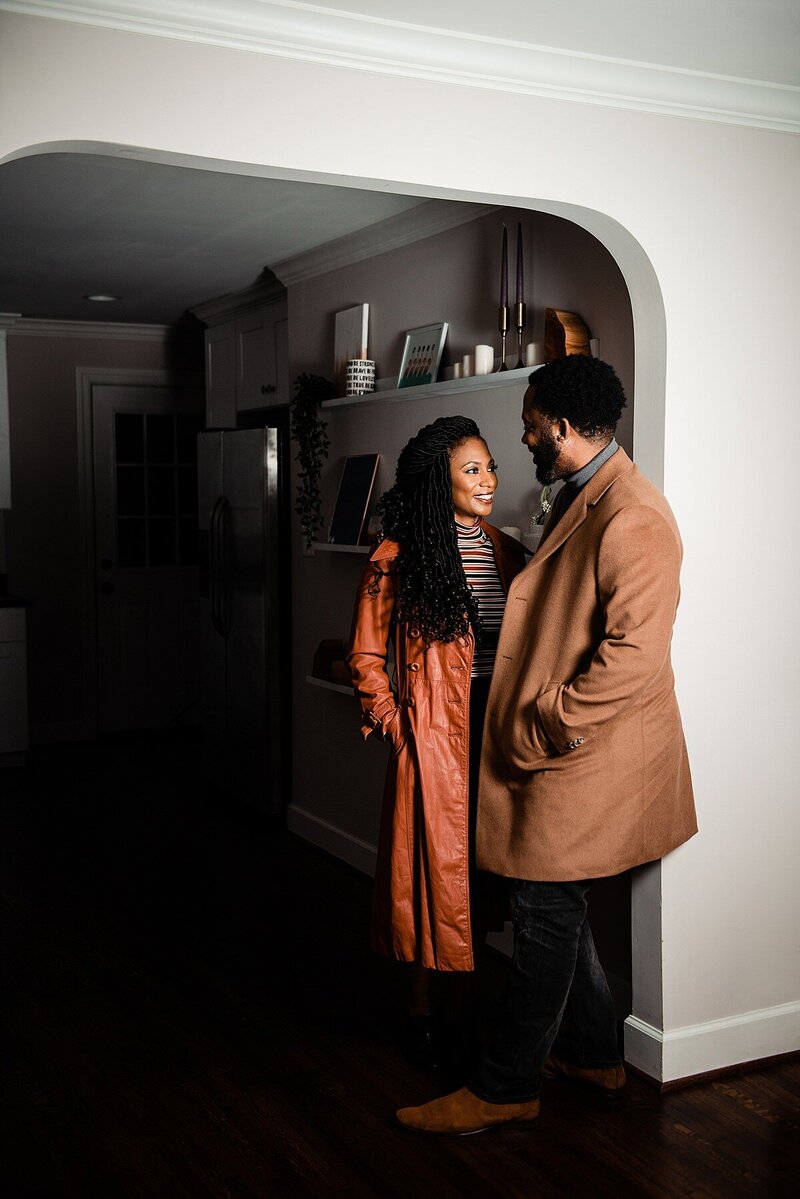 Couple getting ready to go out, wearing fall outfits and long coats