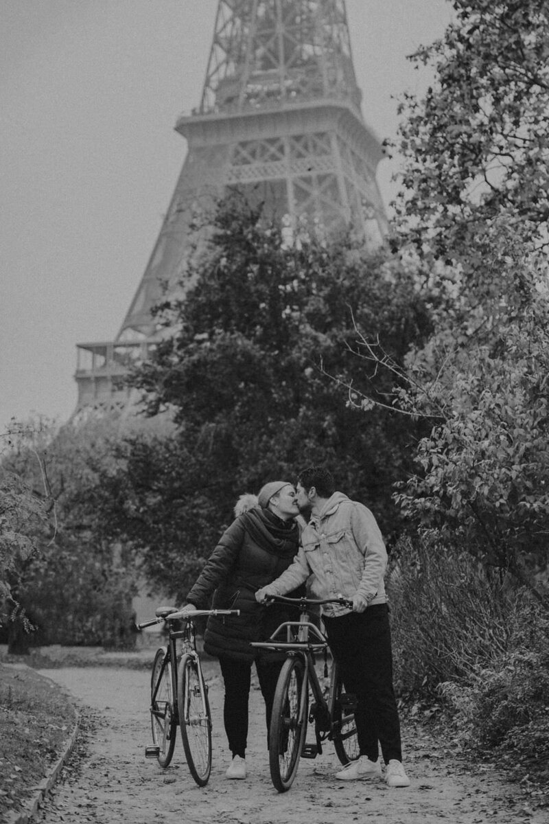 black and white image couple kissing in front of Eiffel Tower