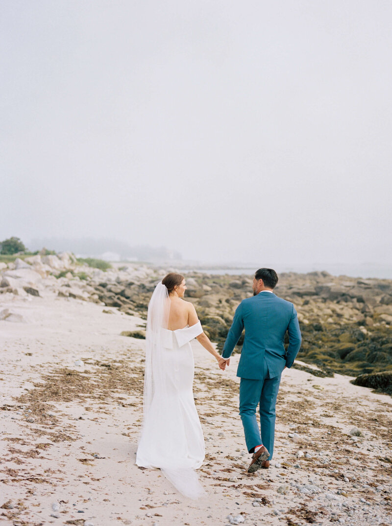 Bride and groom walking along  beach at wedding at Nova Scotia