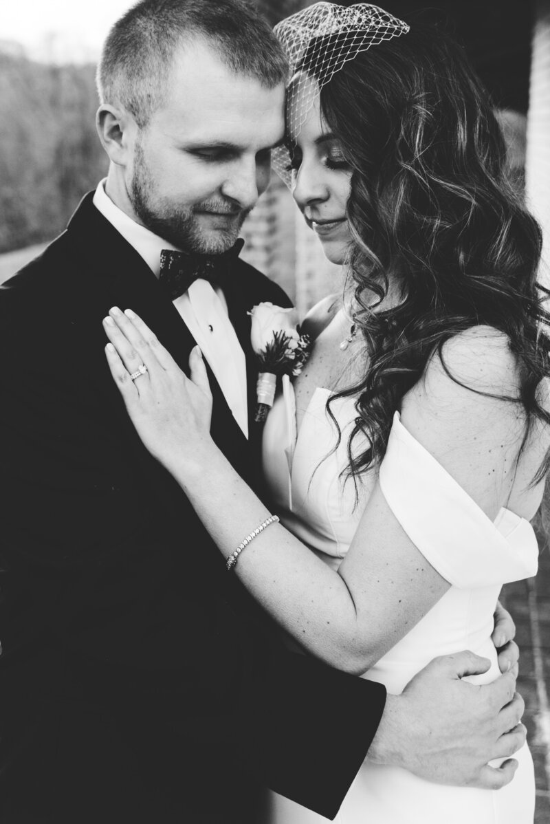 black and white image and bride and groom hugging