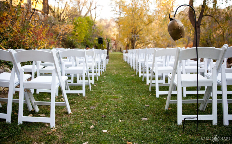 White folding chairs set up for a fall wedding at Boulder Creek Wedgewood Weddings in Colorado