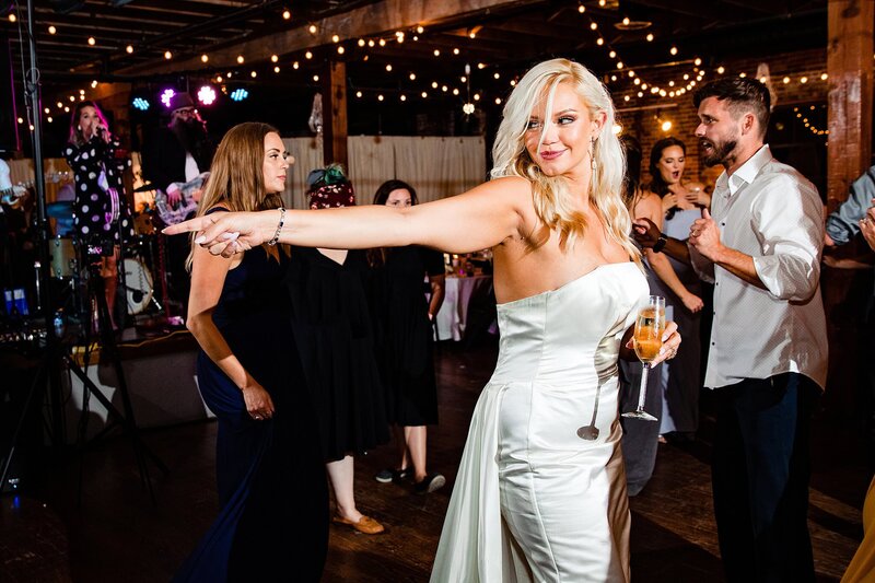Bride dancing on the dance floor with a glass of wine during her reception at Marathon Music Works