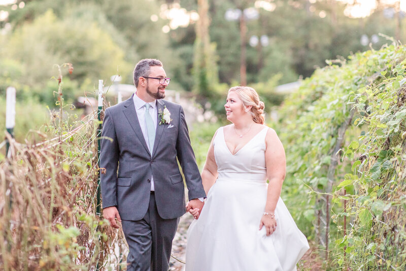 A light and airy photo of a couple walking through a garden after their wedding at the Chattahoochee Nature Center in Roswell Georgia.