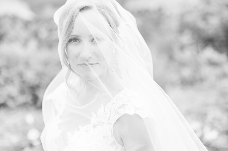 Close up portrait of a bride under her veil in black and white.