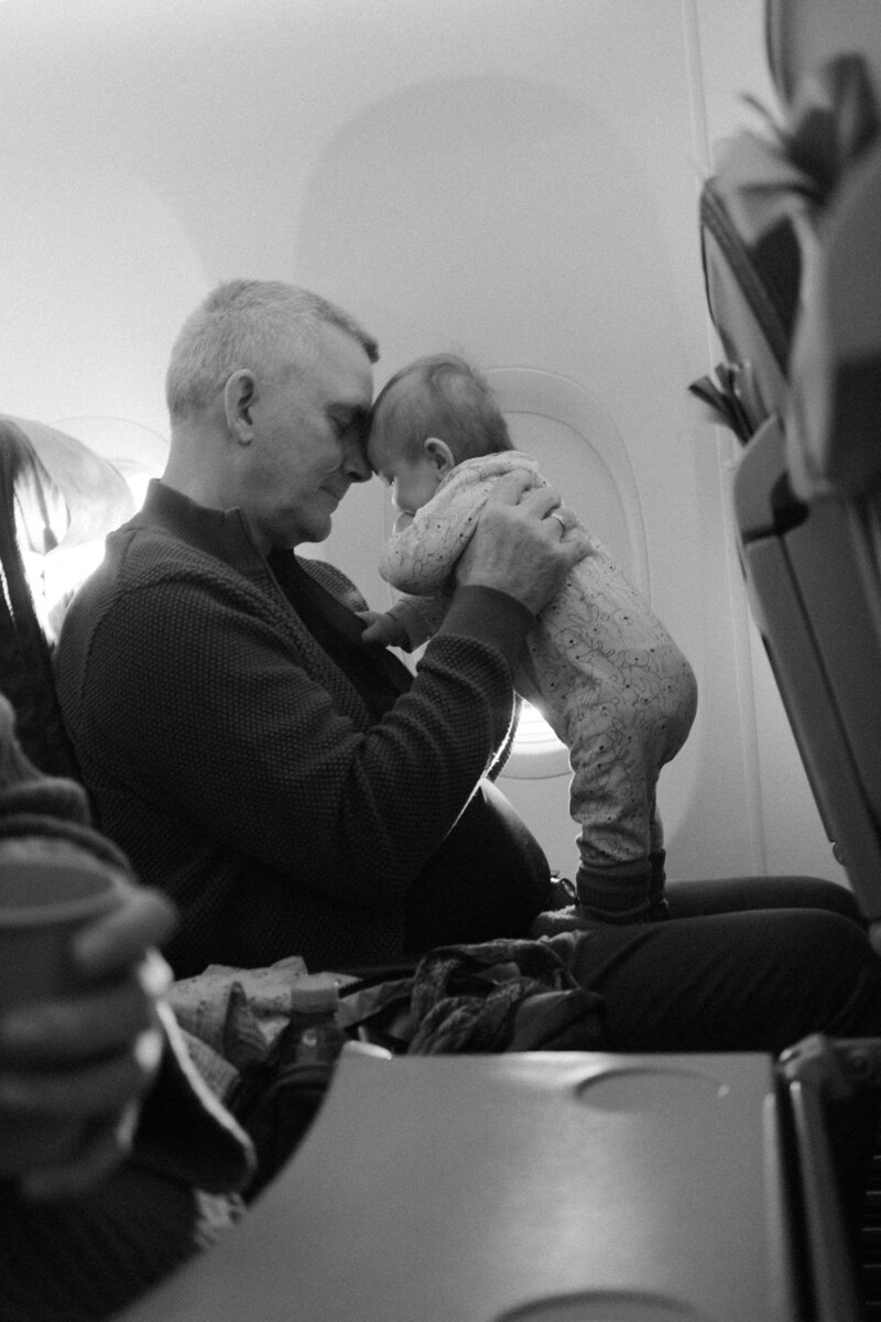 Dad with baby on plane, in black and white