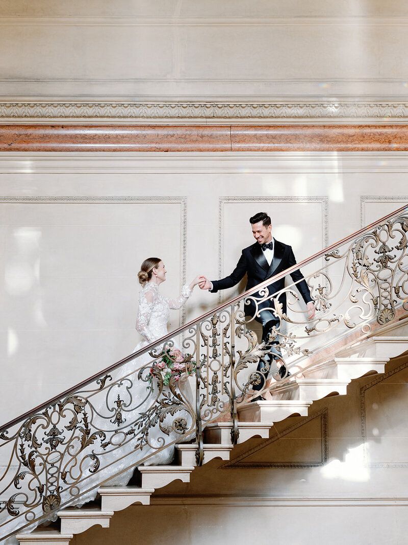 A bride and groom going up the stairs at Larz Anderson house.