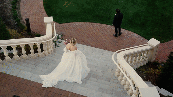 Heartwarming outdoor wedding video of elegant bride and groom kissing and dancing in front of grand staircase by Orlando wedding photographer Four Loves Photos and Film