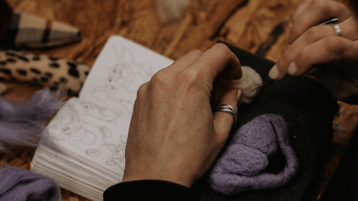 Natalie sewing a woog together