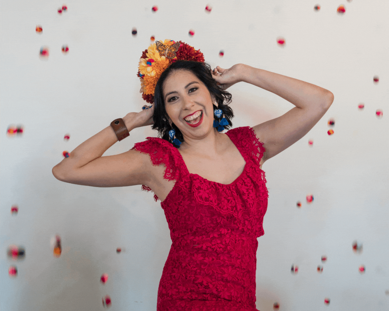 The founder of our craft workshops wears her donned in a captivating red lace dress, a flower crown, and chic accessories, as she dances with colorful confetti against a pristine white canvas. Explore the art of crafting and self-expression at Soleil Vida Studio, where every detail tells a story of inspiration and empowerment.