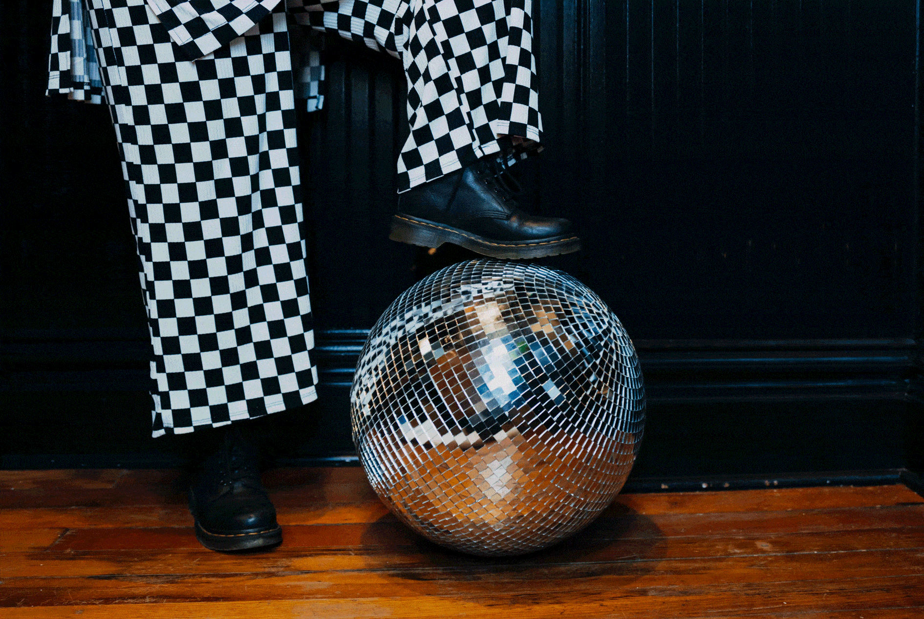 A foot resting on a disco ball.