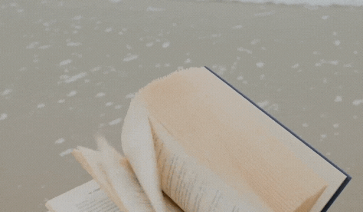 Book pages with ocean waves on the beach