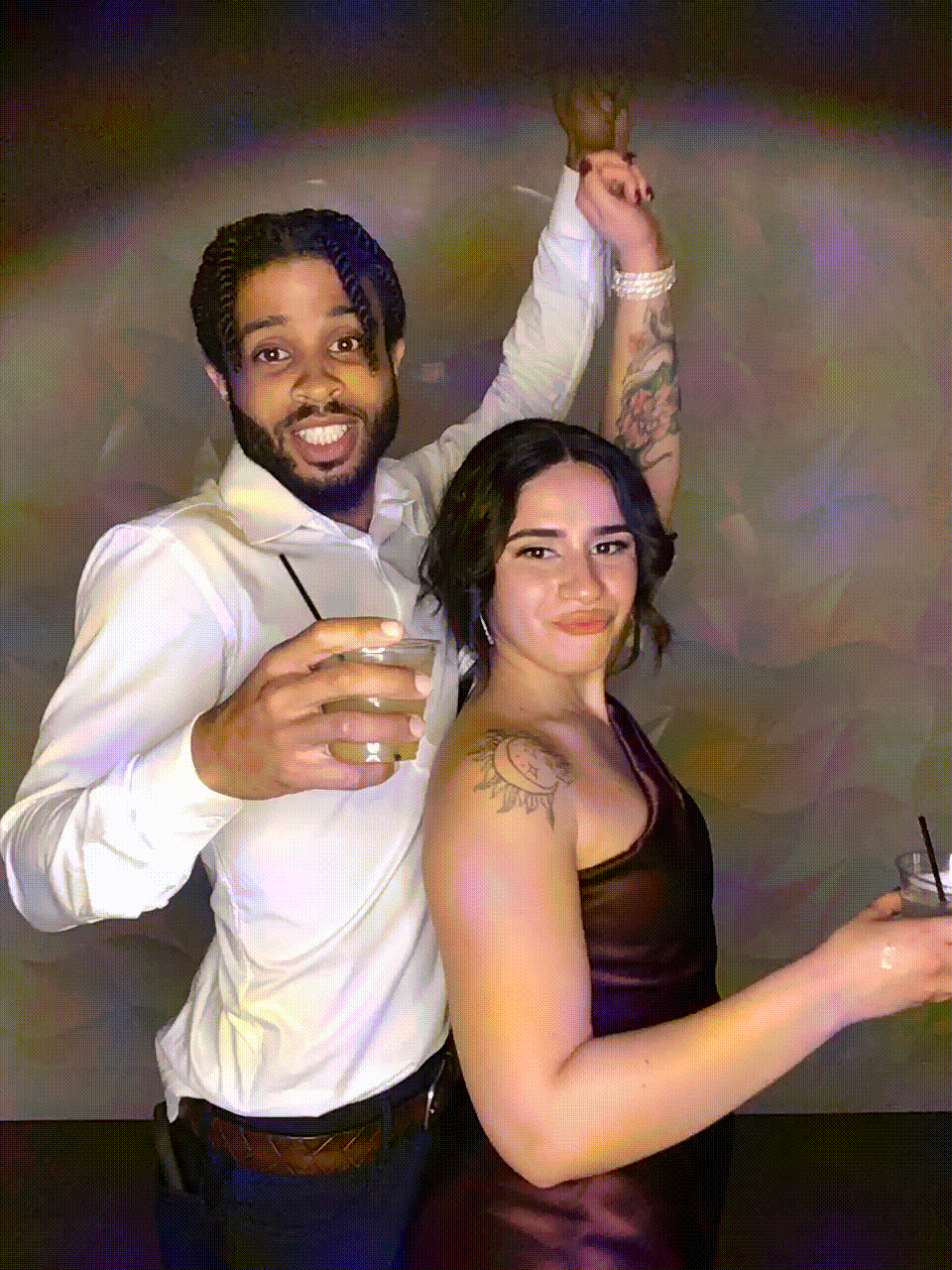 Couple dancing and drinking in photobooth GIF