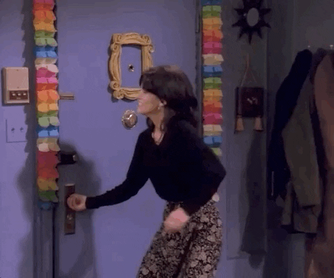 A GIF showing a scene from the TV show Friends, where Ross enters the room with a cake and being scared by the friends, and then subsequently drops the cake