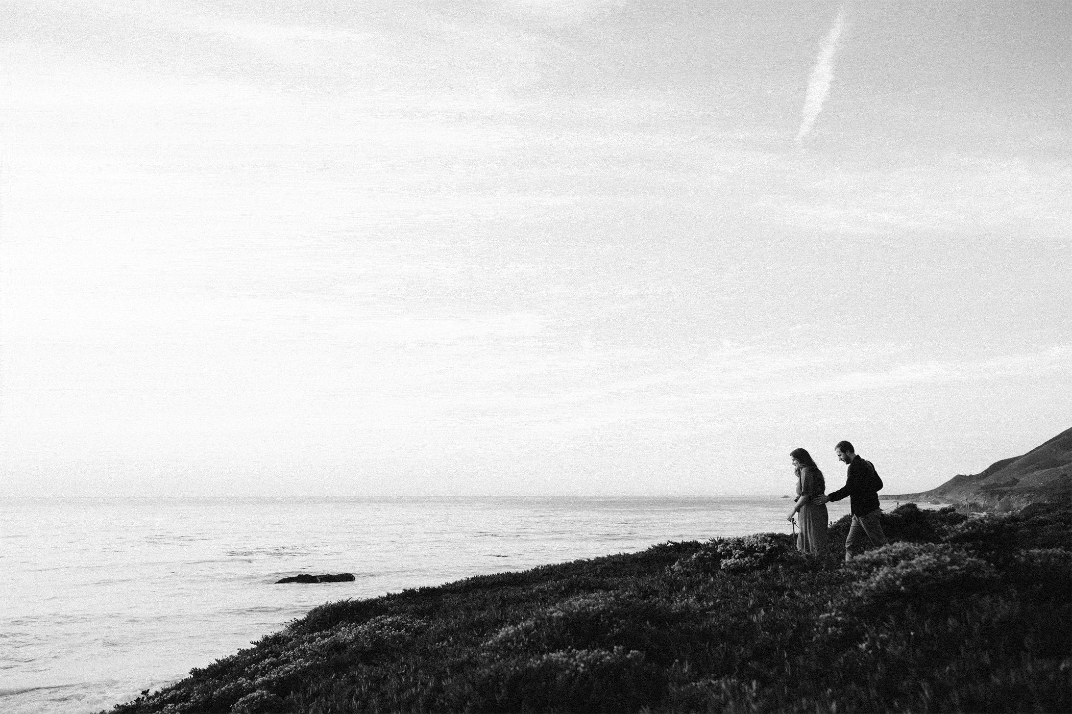 couple walking out on pacific ocean cliff