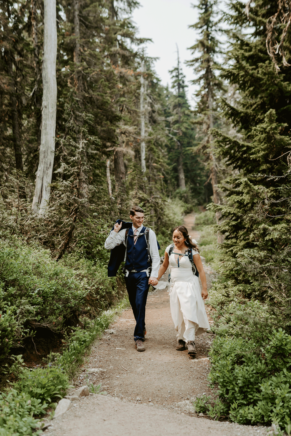 Gif photo of a bride and groom walking down a trail in the forest