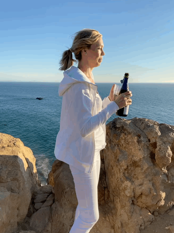 woman with champagne on cliff