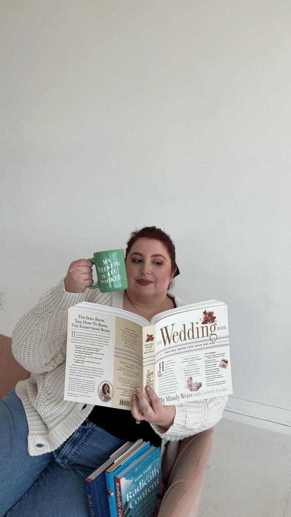 wedding strategist reading book about weddings and cheersing her mug of coffee