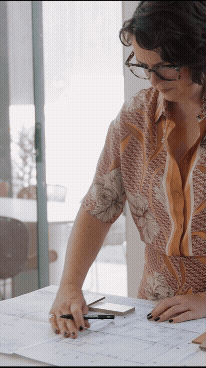 Lisa Hunter Interior Designer working at a desk with interior floor plans with fabric and material swatches