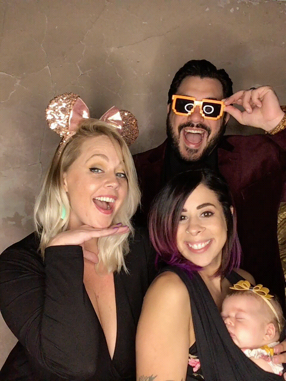 Family together in photo booth wearing props