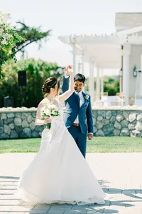 Romantic coastal wedding ceremony in Half Moon Bay, California, featuring a bride and groom with stunning ocean views, sandy beaches, dramatic cliffs, and picturesque sunset skies.