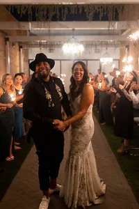 Bride in a lace mermaid-style gown walking together with the groom during their intimate wedding